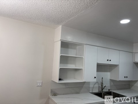 A kitchen with white cabinets and a countertop.