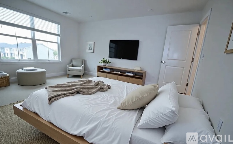 A bedroom with a bed, chair, and window.