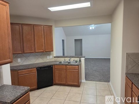 A kitchen with wooden cabinets and a black dishwasher.