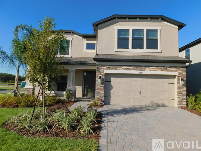 A house with a garage and a driveway in front of it.