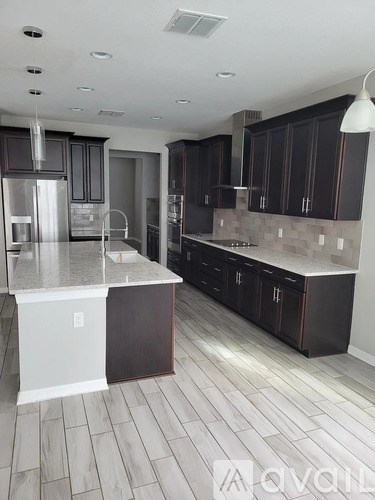 A kitchen with dark brown cabinets and a white island.