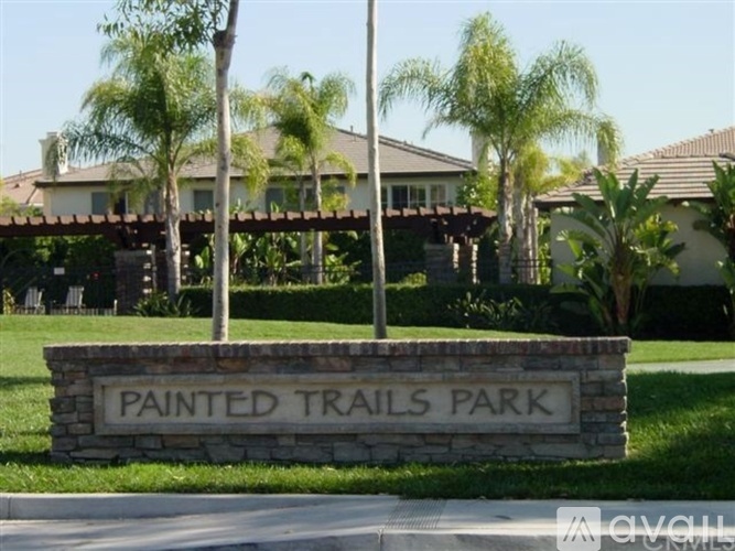 A sign that says Painted Trails Park in front of a building.