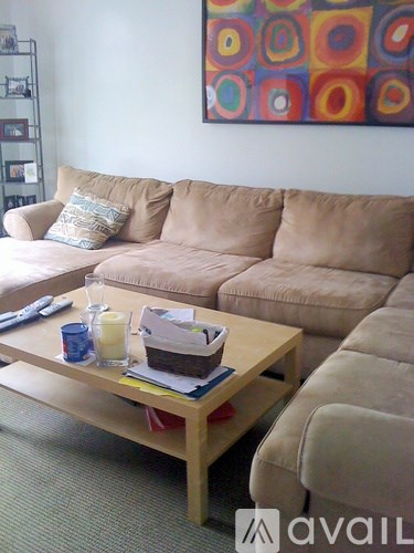 A living room with a beige couch and a wooden coffee table.