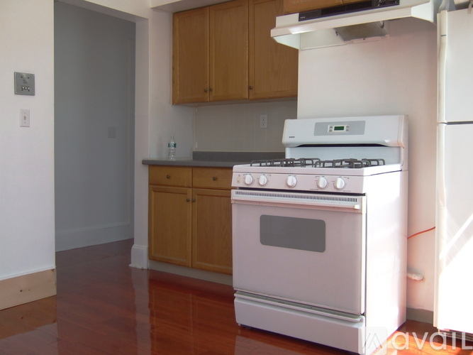 A white oven in a kitchen with wooden cabinets.