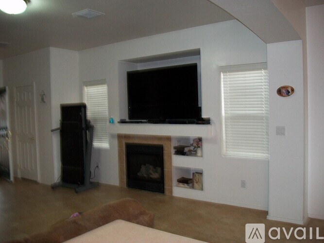 A living room with a fireplace and a television mounted above it.