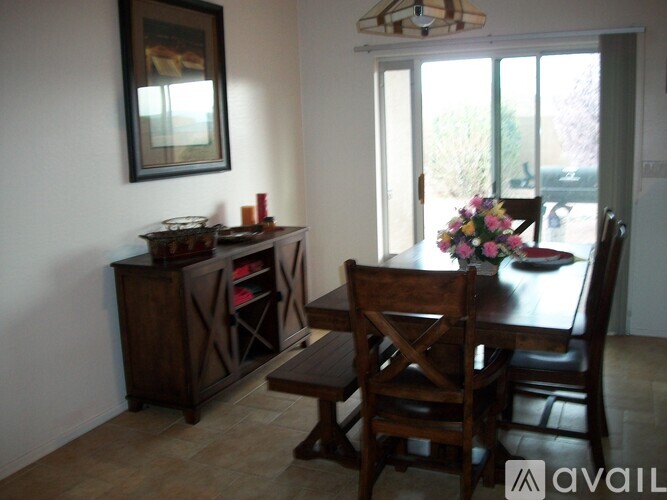 A dining room with a wooden table and chairs.