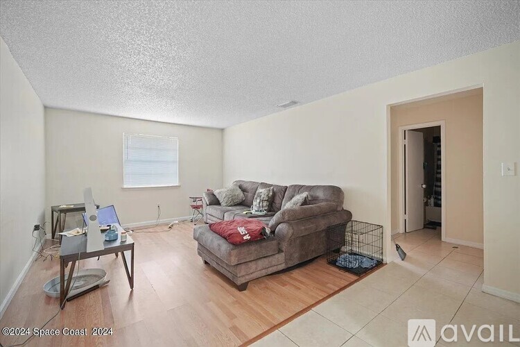 A living room with a couch, a chair, and a coffee table.