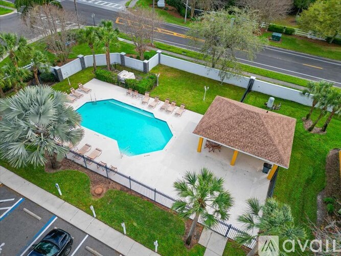 A backyard with a pool and a small house.