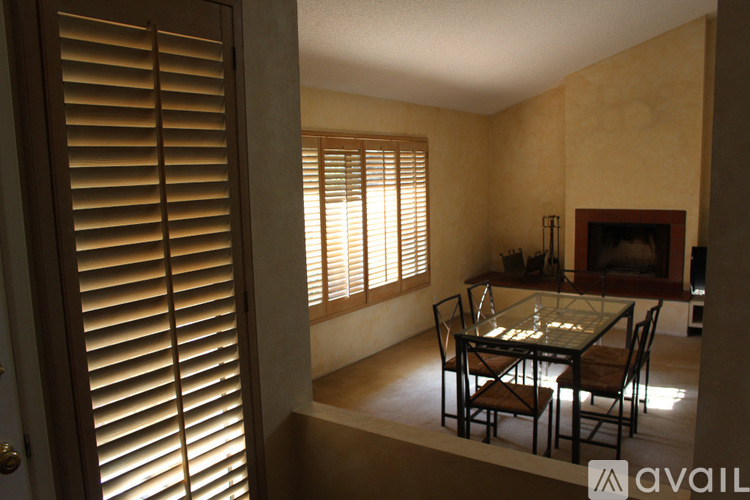A dining room with a glass table and chairs.