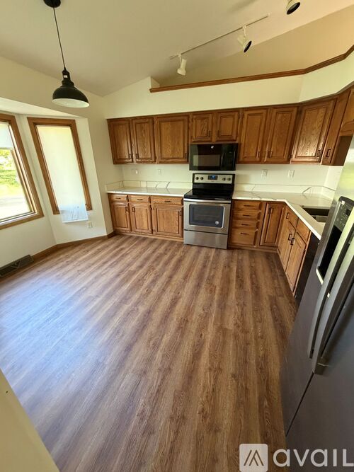 A kitchen with wooden cabinets and a black stove top oven.