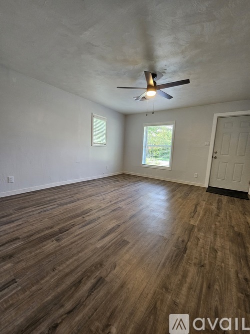 A room with wooden flooring and a ceiling fan.