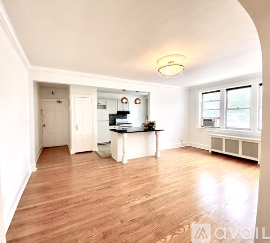 A spacious room with wooden floors and white walls.