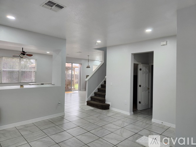 A spacious room with a staircase leading to the upper level.
