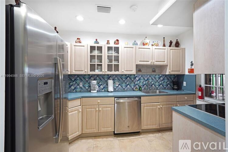 A kitchen with a stainless steel refrigerator and wooden cabinets.