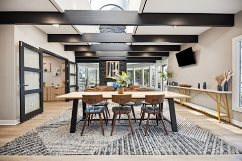 A modern dining room with a large table and chairs.