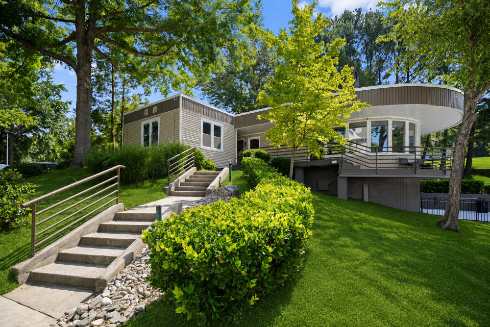 A house with a curved roof and a stone staircase leading to the front door.