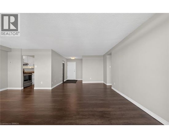 A spacious room with wooden floors and white walls.