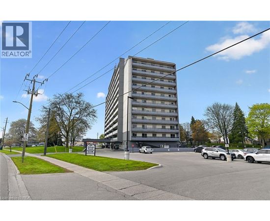 A tall building with a parking lot in front of it.