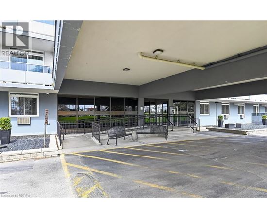A parking lot with a bench and a building in the background.