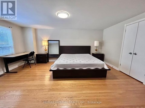 A bedroom with a bed, desk, and chair.