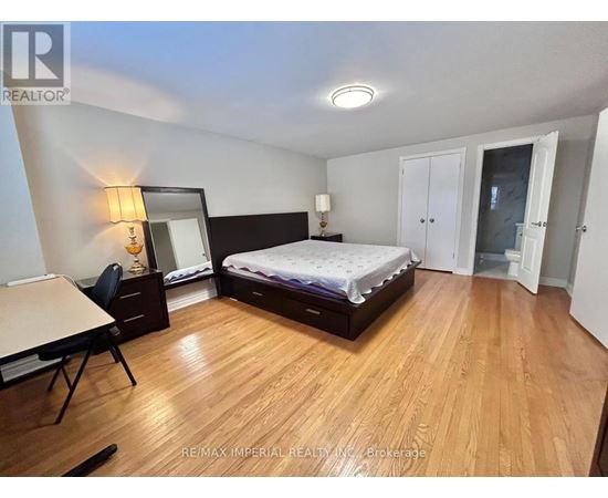 A bedroom with a bed, desk, and chair.