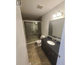 A bathroom with a sink, mirror, toilet and shower.