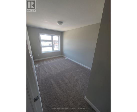A carpeted room with a door and a window.