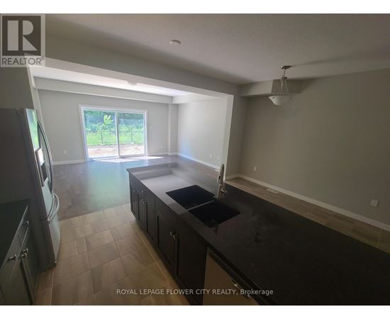 A kitchen with a black counter top and a window.