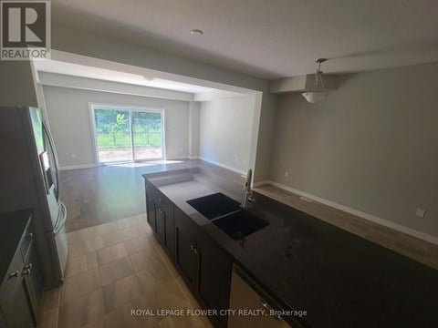 A kitchen with a black counter top and a window.