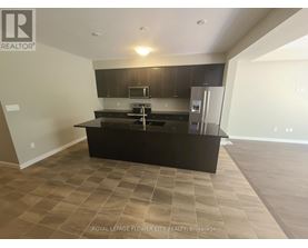 A kitchen with a black countertop and a refrigerator.