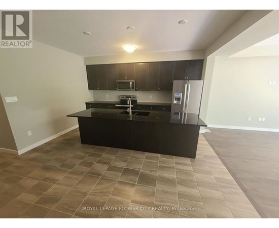 A kitchen with a black countertop and a refrigerator.