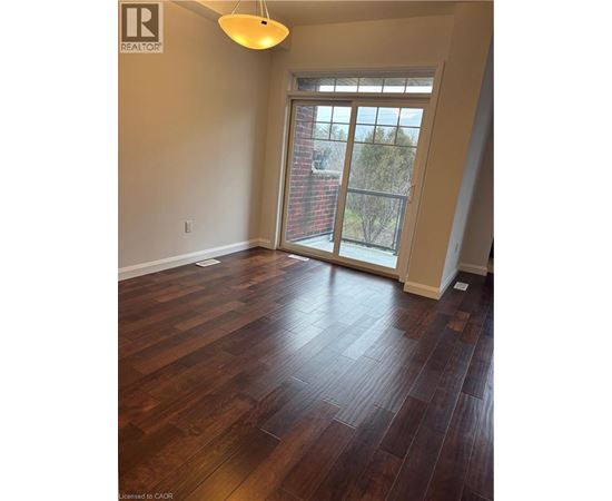 A room with wooden flooring and a sliding glass door.