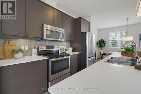 A kitchen with a white counter top and dark brown cabinets.