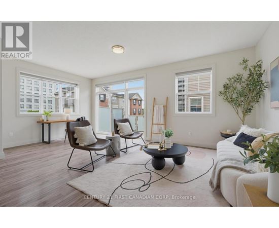 A living room with a couch, chairs, and a table with a plant on it.