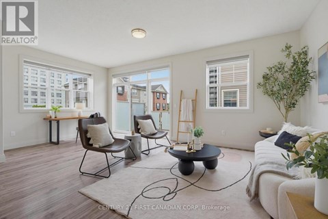 A living room with a couch, chairs, and a table with a plant on it.