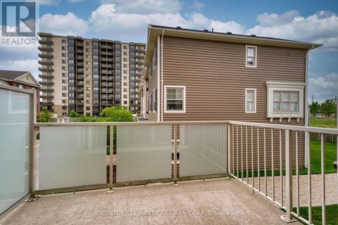 A house with a fence and a building in the background.