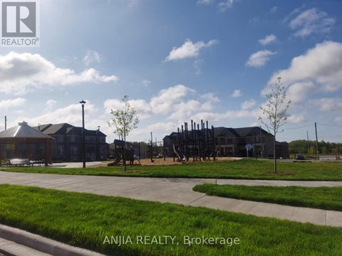 A sunny day at Brokerage with a building and a playground.