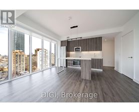 A modern kitchen with a view of the cityscape outside the large windows.