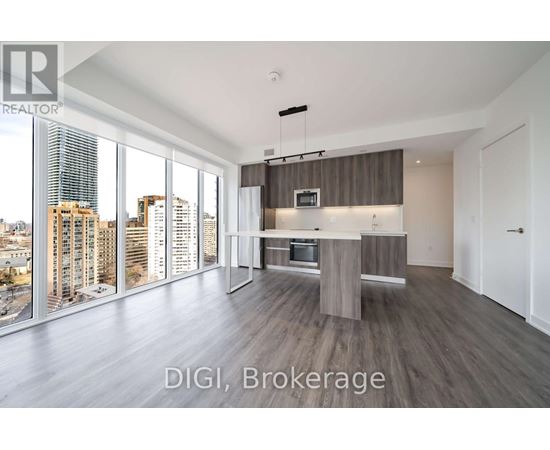 A modern kitchen with a view of the cityscape outside the large windows.