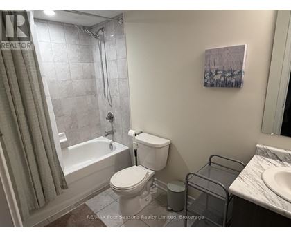 A bathroom with a toilet, sink, and shower.