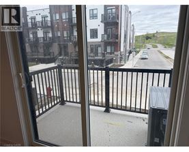 A view from a window looking out at a street with buildings on either side.