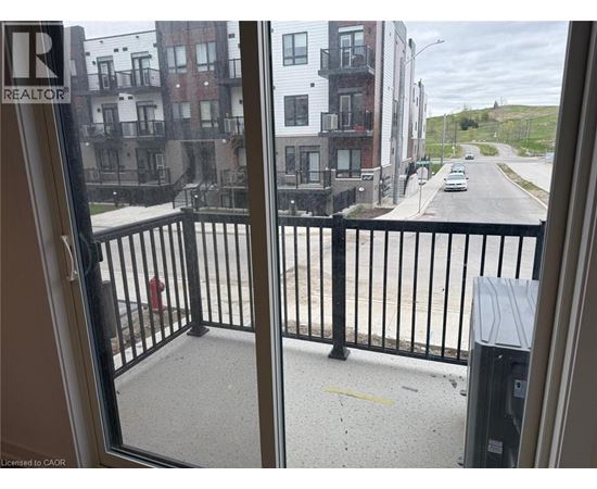 A view from a window looking out at a street with buildings on either side.