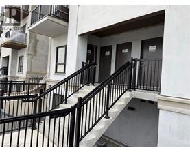 A staircase with black railings leads to a door.