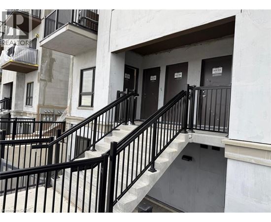 A staircase with black railings leads to a door.
