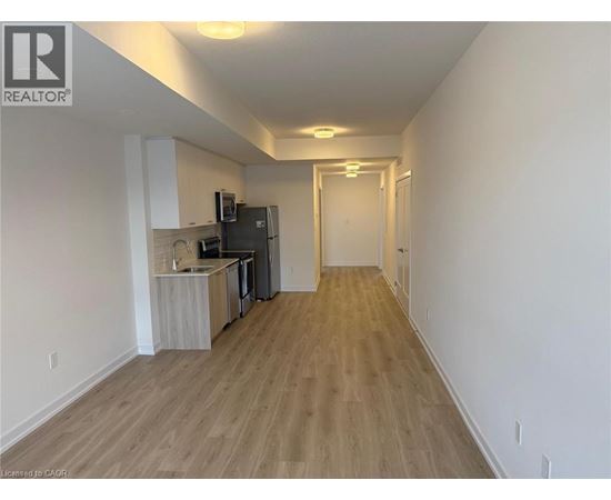 A long hallway with a kitchen area on the left side.