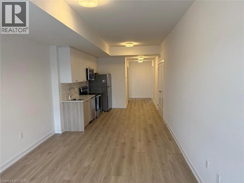 A long hallway with a kitchen area on the left side.