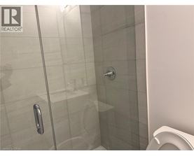 A glass shower door with a handle is in the foreground.