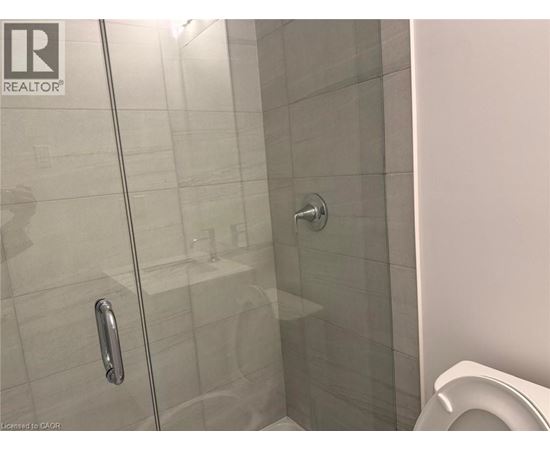 A glass shower door with a handle is in the foreground.