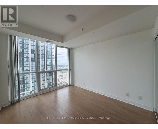 A room with a view of a cityscape through large windows.