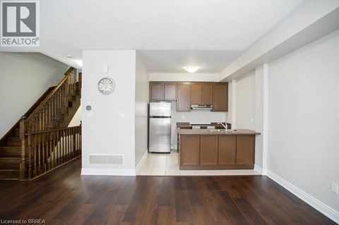 A kitchen with wooden cabinets and a stainless steel refrigerator.